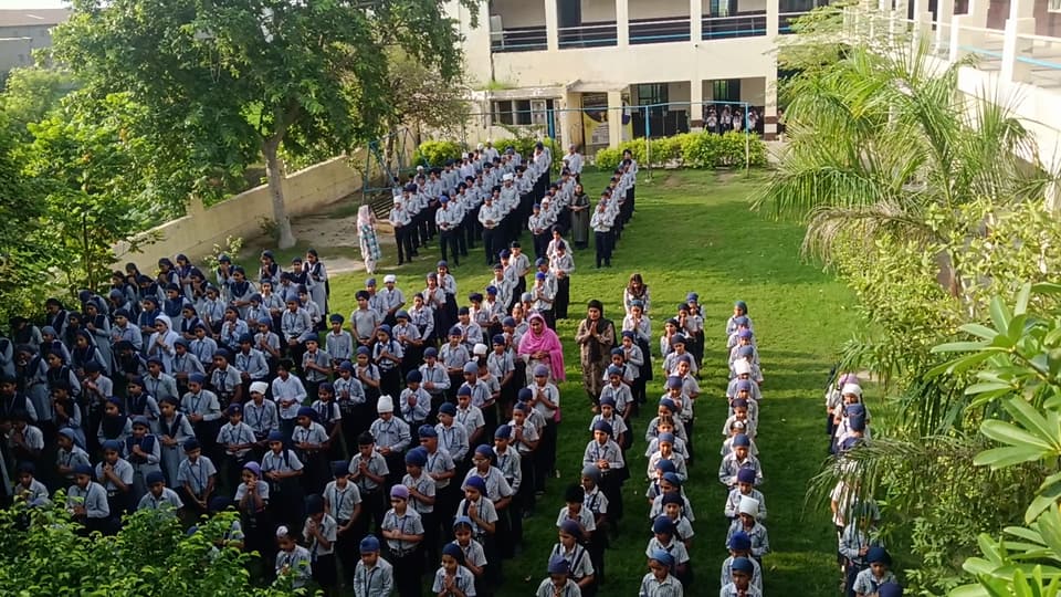 The whole school assembled in rows on the lawn, seen from above